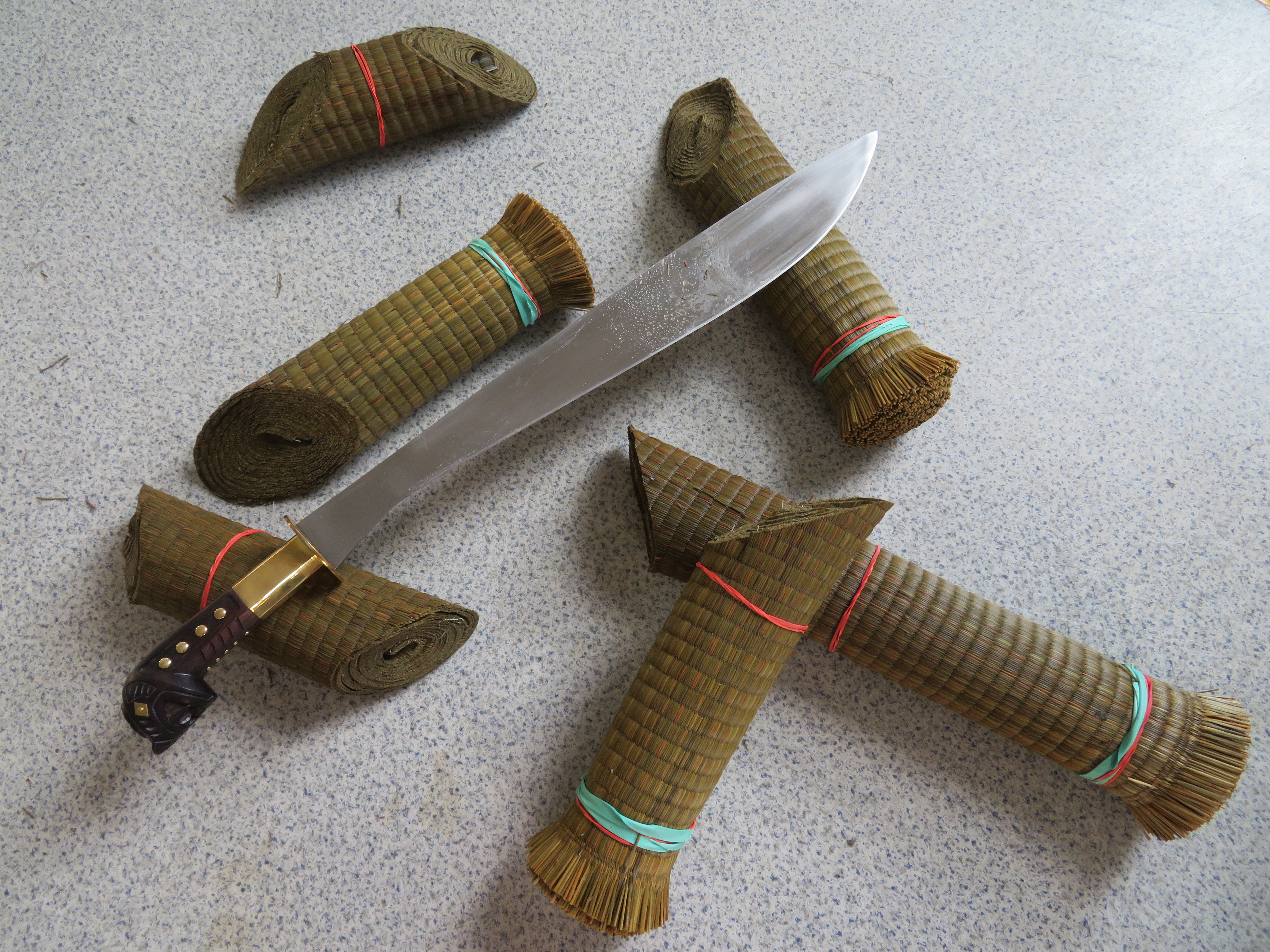 Rozsekané smotané namočené trávové rohože tatami omote a model Filipino Memorial Bolo těsně po sekacích testech.