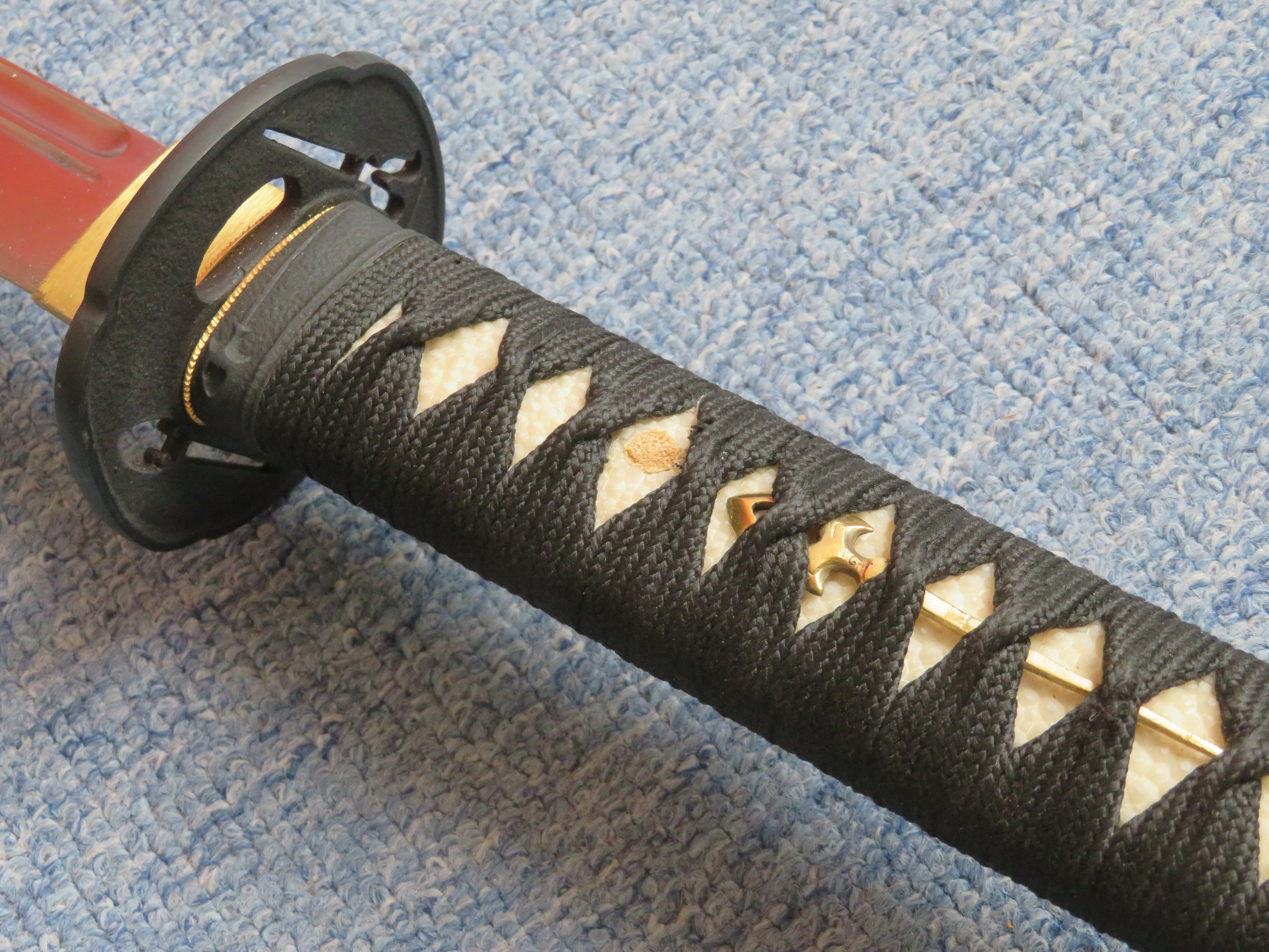 Detail rukojeti/cuka meče Nodachi s opletem a záštitou nazývanou tsuba.